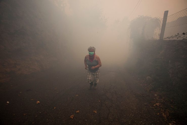Unha muller en Vincios (Gondomar), no medio do fume causado pola vaga de incendios que asolou Galicia en pleno mes de outubro de 2017 / 1.1 Fotografía.
