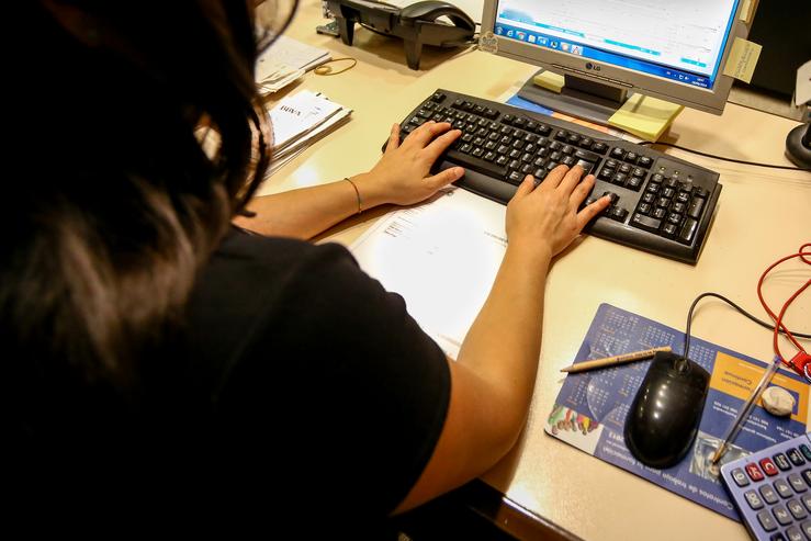 Unha muller escribe no teclado do seu computador, no despacho da oficina.. Ricardo Rubio - Europa Press 