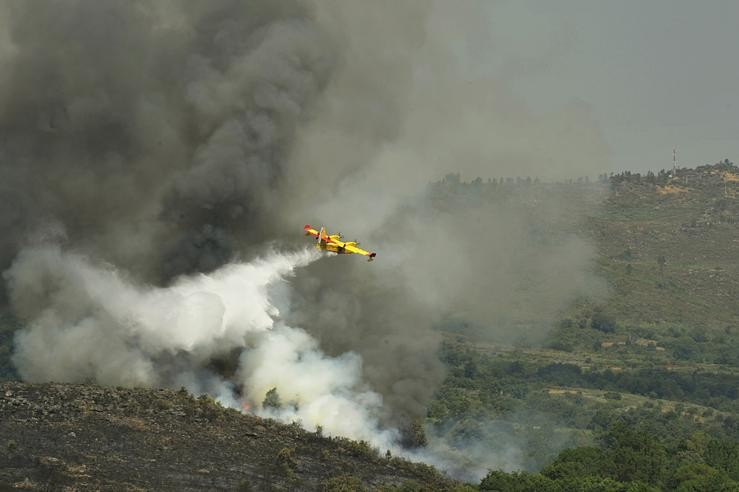 Un avión apaga lumes da UME sobrevoa e verte auga sobre o incendio de Cualedro 
