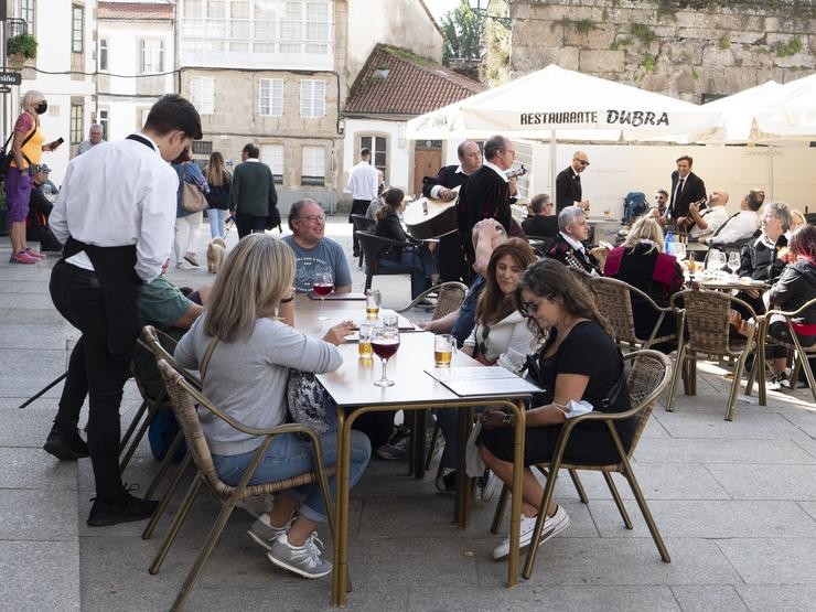 Un grupo de turistas consulta unha carta na terraza dun bar en Santiago de Compostela / César Argina - Europa Press  / Europa Press