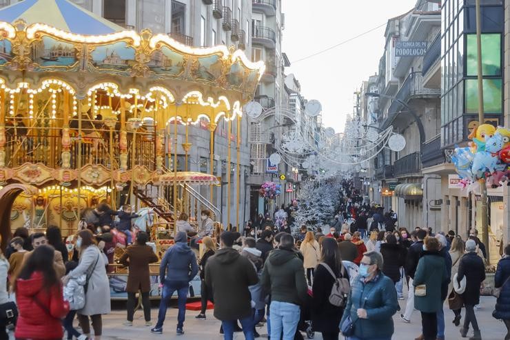 Un grupo de persoas observa o aceso do Nadal tras varios días de choiva, a 12 de decembro de 2021, en Vigo.. Marta Vázquez Rodríguez - Europa Press