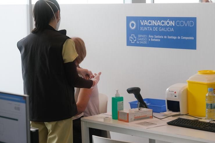 Un sanitario administra a primeira dose da vacina AstraZeneca contra a COVID-19 na Cidade da Cultura de Santiago 