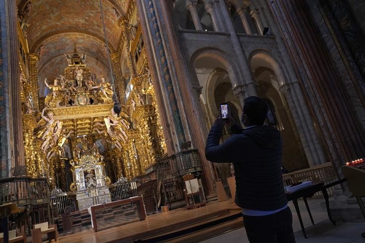 Un turista bota unhas fotos no interior da Catedral de Santiago durante a ponte de San José 