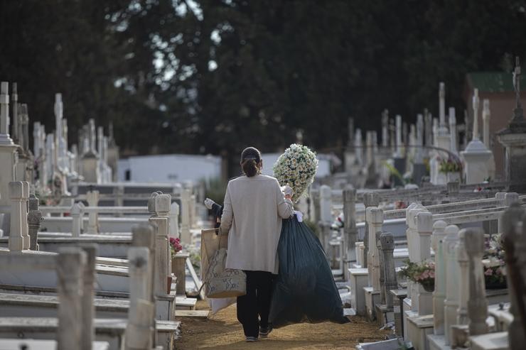 Unha muller camiña entre as lápidas dun cemiterio / María José López - Arquivo