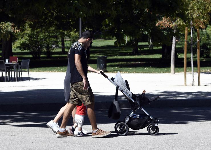 Unha parella e o seu bebé empuxan o carriño do mesmo nun parque / Óscar Cañas - Europa Press