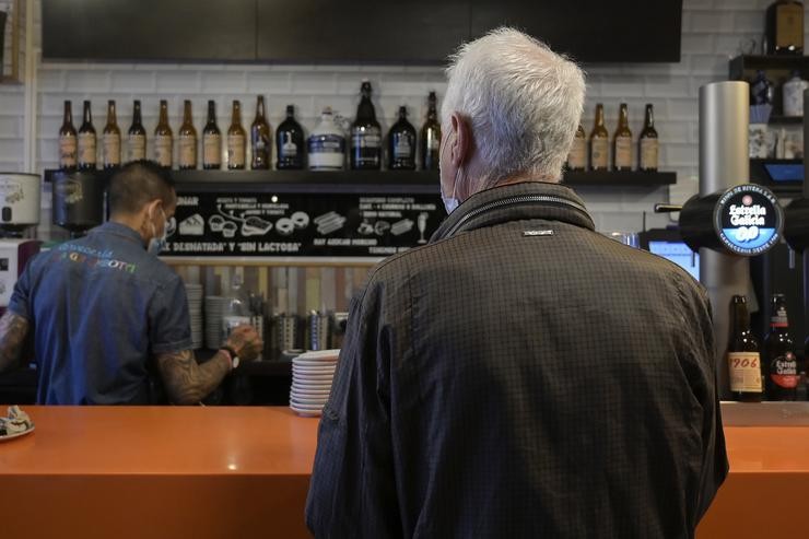 Un home na barra dun bar coruñés o día en que reabren as barras dos establecementos de hostalaría por primeira vez na pandemia do coronavirus en Galicia, a 15 de setembro de 2021, na Coruña 