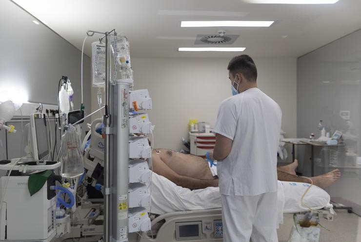 Un sanitario ao redor dun paciente ingresado na UCI / Eduardo Parra - Arquivo