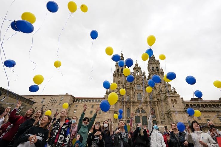 Varias persoas lanzan globos ao aire como xesto para o fin da guerra en Ucraína, na praza do Obradoiro/ Álvaro Ballesteros / Europa Press