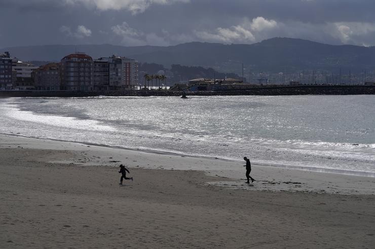 Varias persoas pasean pola praia de Silgar en Sanxenxo. Álvaro Ballesteros - Europa Press