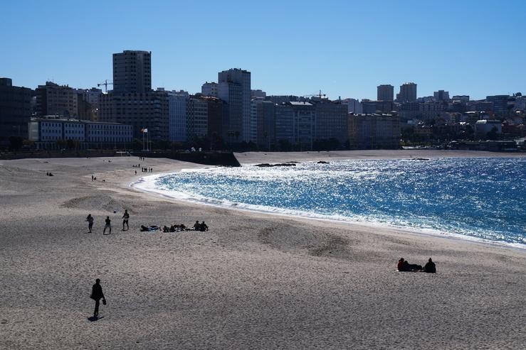 Varias persoas nas praias Orzán e Riazor, a 8 de abril de 2022, na Coruña 