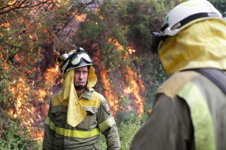 Axentes das Brigadas de Reforzo en Incendios Forestais (BRIF) realizan labores de extinción nas inmediacións dun incendio en Samos 
