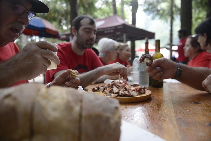 Un grupo de persoas come polbo na festa do Carballiño 2022 / Rosa Veiga - Europa Press.