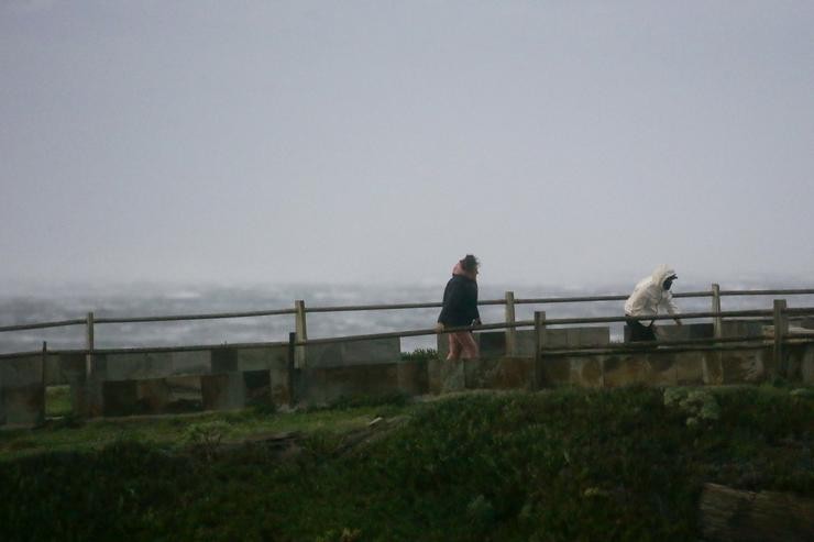 Dúas persoas observan a ondada durante a entrada da borrasca Ciarán 