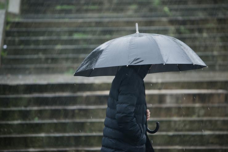 Unha persoa con paraugas para protexerse da choiva 