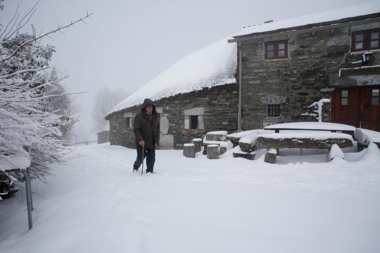 Un home camiña por unha rúa cuberta de neve, a 26 de xaneiro de 2023, en Pedrafita do Cebreiro, Lugo, Galicia (España). Hai un corredor que forman o anticiclón ao norte da Península e unha borrasca sobre o Mediterráneo, o que está a provocar direc. Carlos Castro - Europa Press / Europa Press