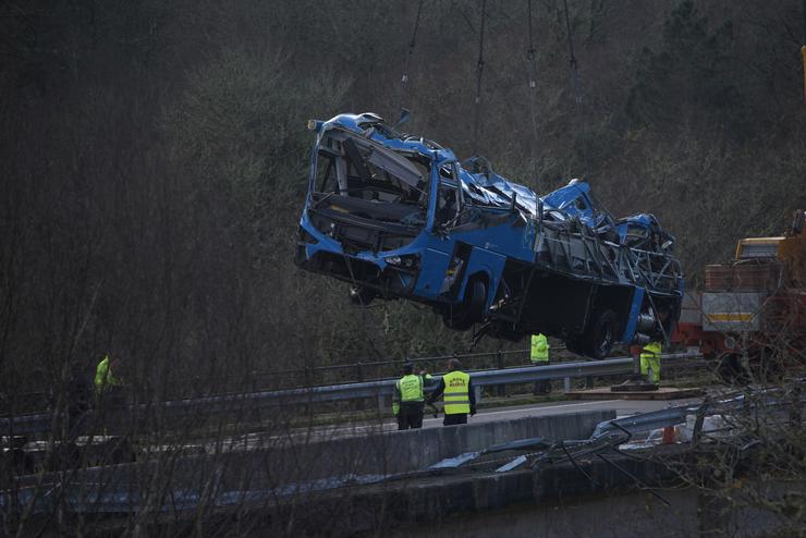 Un guindastre coloca o autobús accidentado sobre a ponte para sacalo da canle do río Lérez, a 27 de decembro de 2022, en Cerdedo-Cotobade 