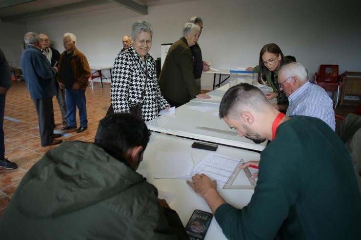 Varias persoas exercen o seu dereito a voto na mesa electoral do local parroquial de Recelle 