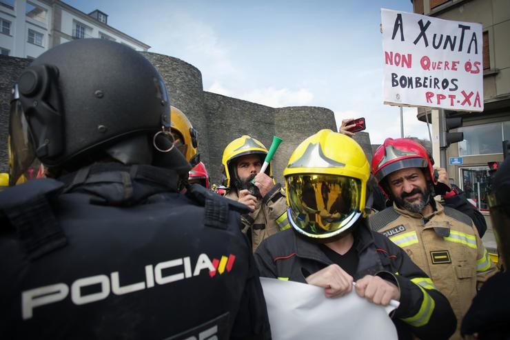Antidisturbios da Policía durante a protesta de bombeiros de consorcios provinciais ao tentar colocar unha pancarta ante a sede da Xunta 