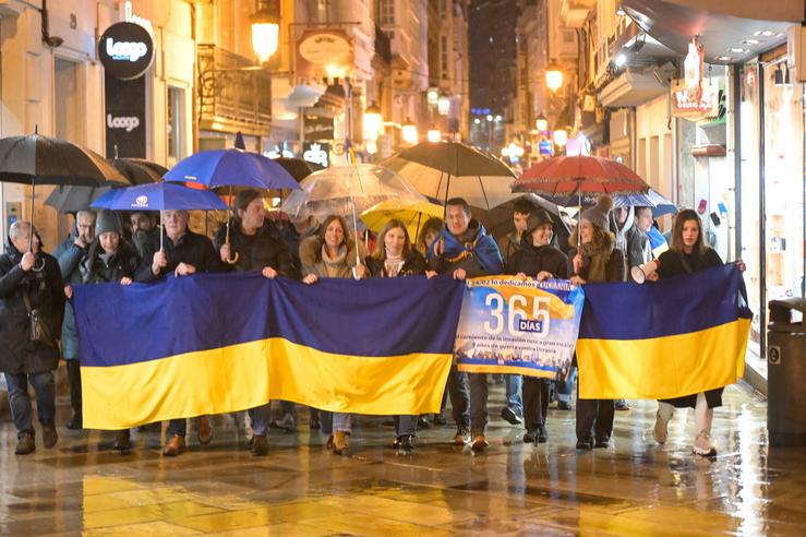 Un grupo de persoas suxeitan bandeiras de Ucraína durante unha manifestación contra a invasión rusa de Ucraína 