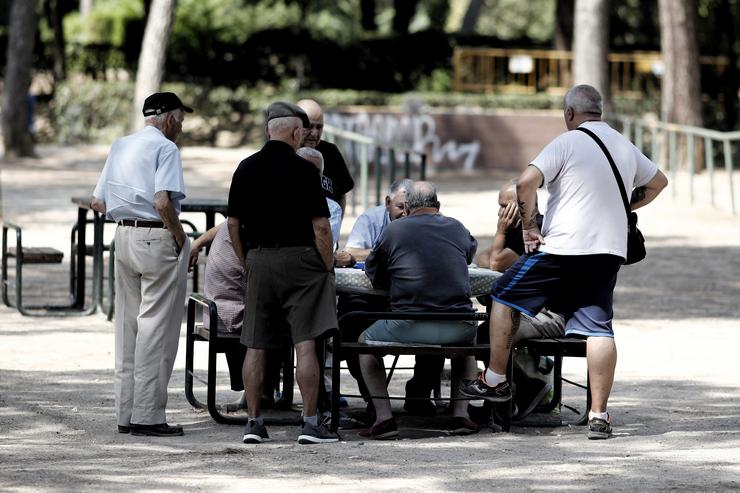 Varios pensionistas e xubiliados xogan ao dominó nun parque  / Eduardo Parra - Arquivo