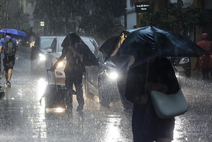 Varias persoas con paraugas baixo a choiva /Rober Solsona - Arquivo