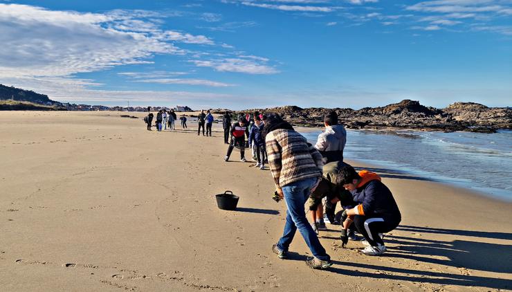 Estudantes do IES Porto do Son colaboran na recollida dos pélets na praia de Cabeiro 