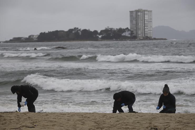 Voluntarios limpan pellets na praia de Samil, a 10 de xaneiro de 2024, en Vigo 