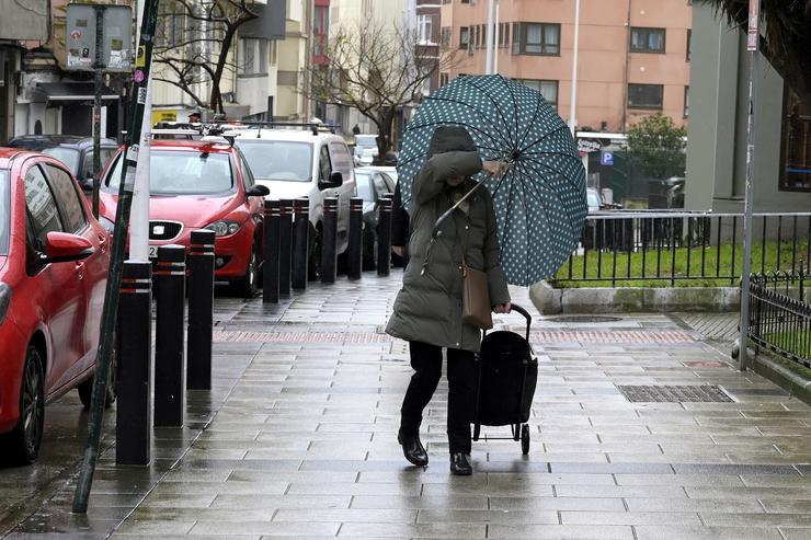 Unha muller refúxiase do vento con paraugas, a 8 de febreiro de 2024, na Coruña. M. Dylan - Europa Press 
