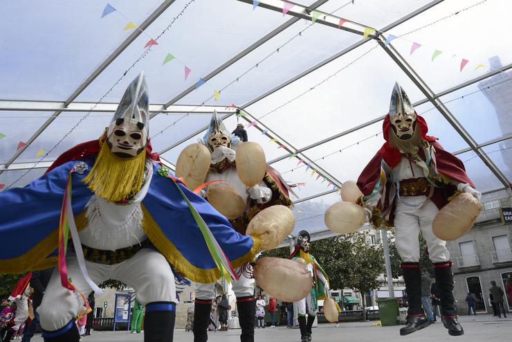 Varias persoas asisten ao desfile de charangas na celebración do Domingo de Piñata, durante a celebración do Entroido de Xinzo de limia 