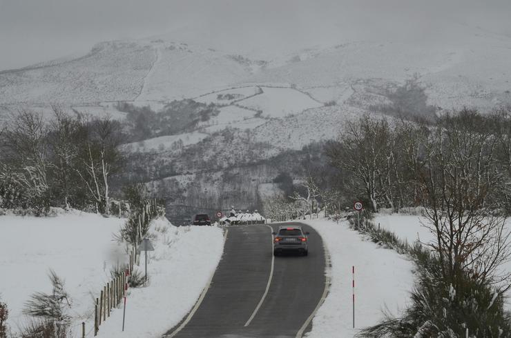 Dous coches circulan por unha paisaxe nevada, a 24 de febreiro de 2024, en Chandrexa de Queixa 